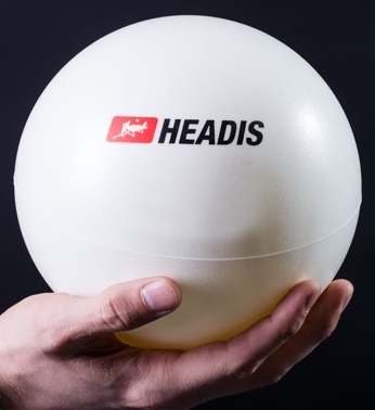 Nahaufnahme eines Headis-Balls, der von einer Hand gehalten wird. Der Ball ist mit dem Headis-Logo bedruckt.