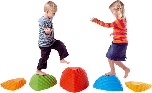Zwei Kinder balancieren auf bunten Balance-Steinen in einem spielerischen Umfeld
