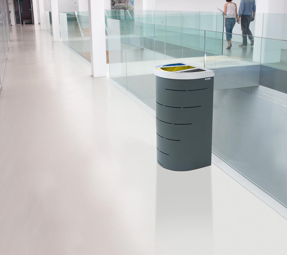 Ein stilvoller Mülleimer im Flur eines modernen Bürogebäudes mit Glasgeländern.