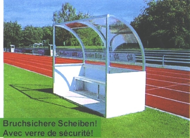 Ersatzbank mit bruchsicheren Scheiben aus Glas auf einem Sportplatz neben einer Laufbahn
