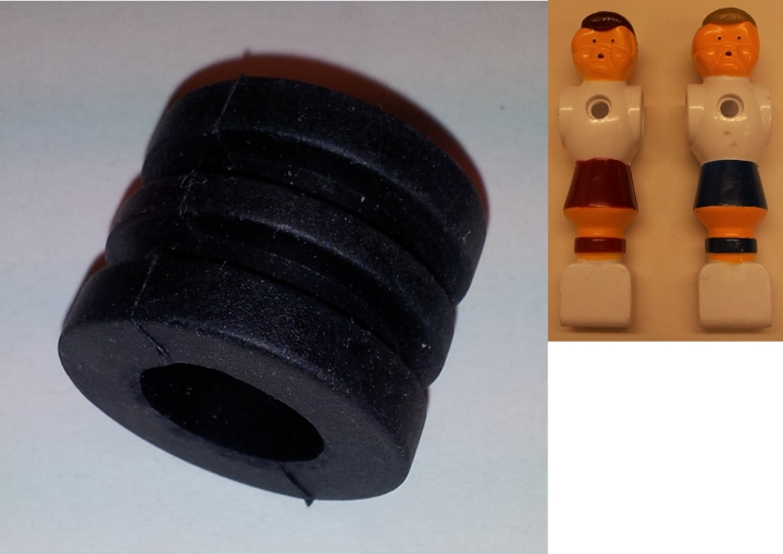 Nahaufnahme von Tischkicker-Ersatzteilen, bestehend aus einem schwarzen Gummipuffer und zwei weiß gekleideten Spielfiguren mit unterschiedlichen Hosenfarben, auf einem hellen Hintergrund.