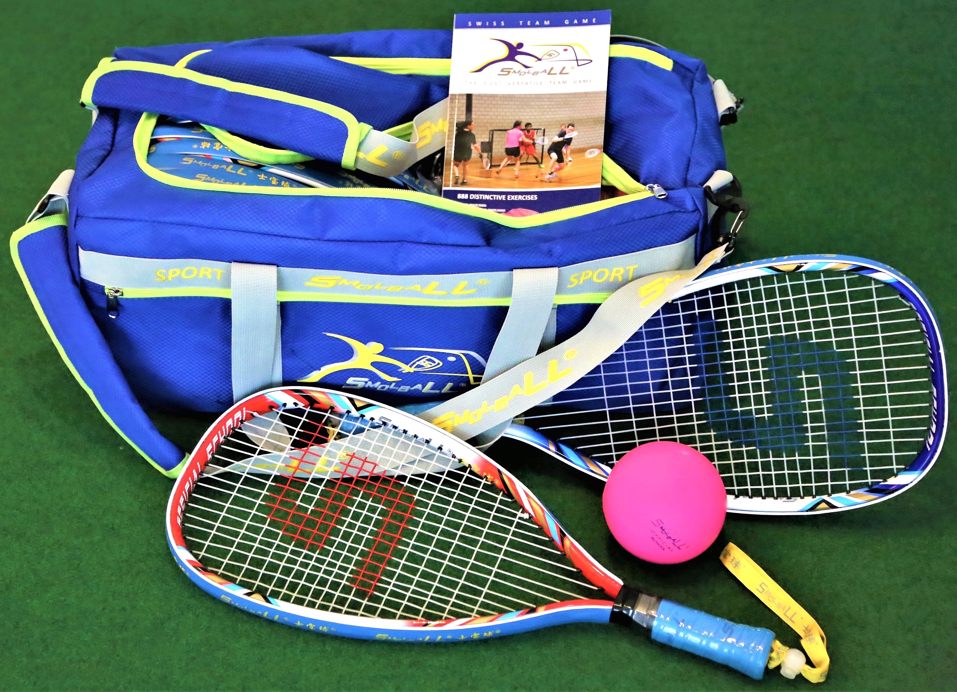 Eine blaue Sporttasche mit Smollball-Schlägern und einem pinken Ball auf einem grünen Hintergrund.