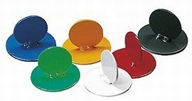 Sechs farbenfrohe runde Magneten in verschiedenen Farben wie blau, gelb, grün, schwarz, rot und weiß auf einer weißen Fläche.